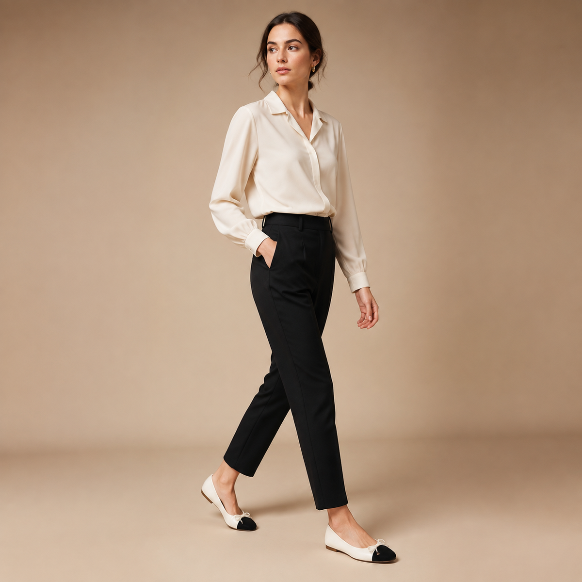 Crèmekleurige ballerina's met zwarte neus, gecombineerd met een lichte blouse en zwarte broek.