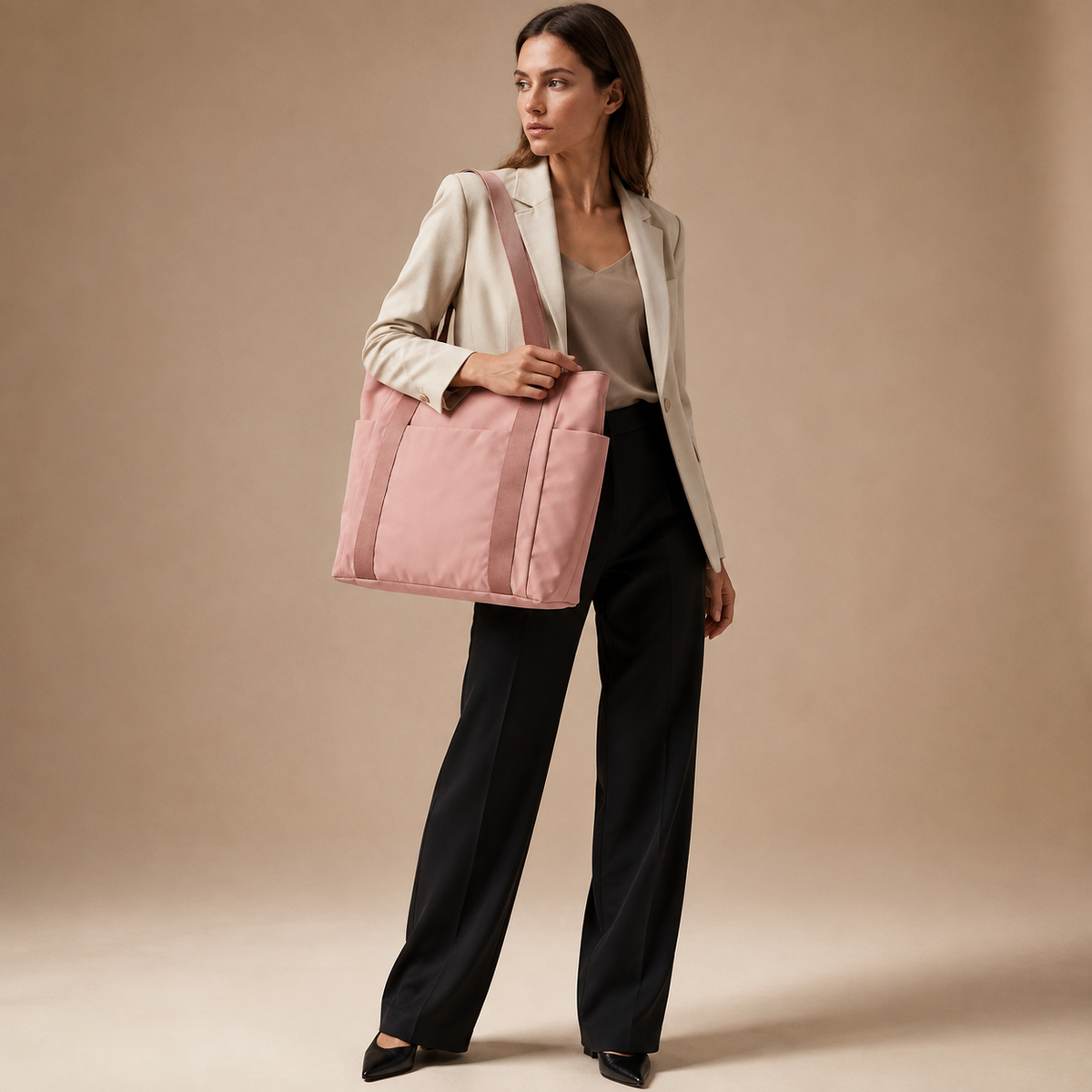 Roze shopper gedragen bij een lichte blazer en zwarte broek, volledige outfit.