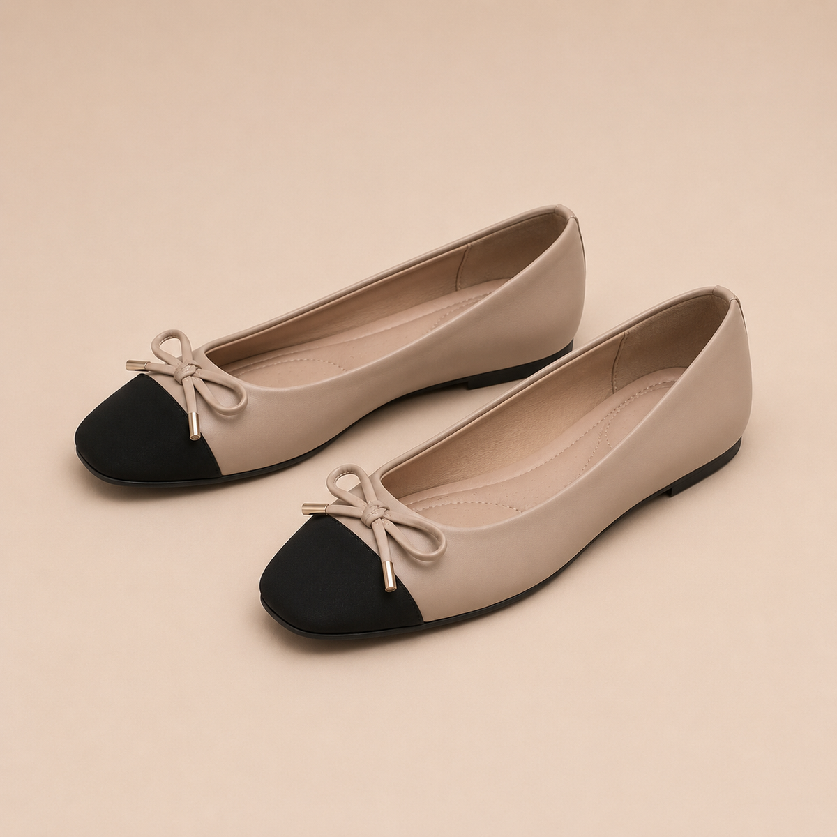 Paar taupekleurige ballerina's met zwarte vierkante neus en bijpassende strik.