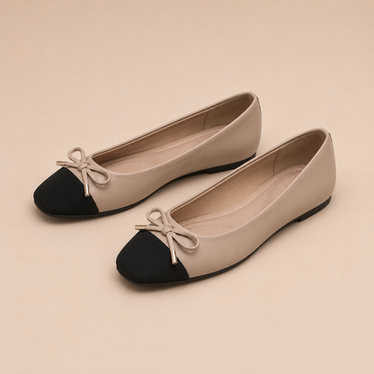 Paar taupekleurige ballerina's met zwarte vierkante neus en bijpassende strik.