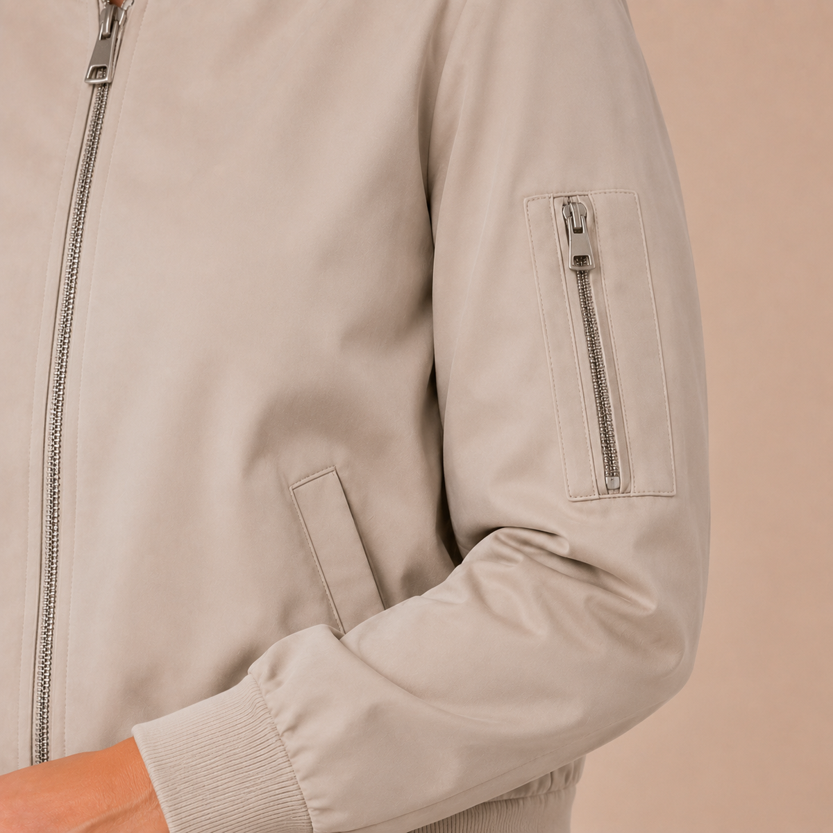 Bomberjack dames casual – korte tussenjas met rits en mouwzak in khaki – detailopname op beige studioachtergrond