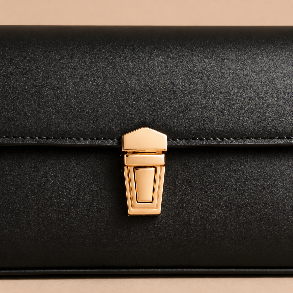 Detail van gouden sluiting en zwart leer op dames handtas