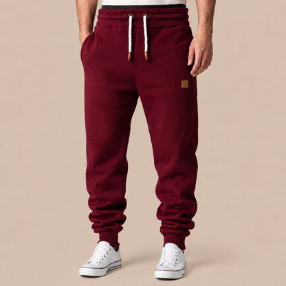 Joggingbroek Heren Casual - Sweatpants met Trekkoord Zijzakken en Elastische Boorden in bordeauxrood – productgericht vooraanzicht op beige studioachtergrond