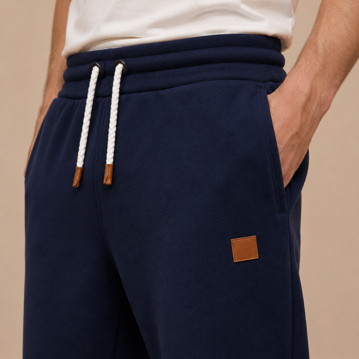 Joggingbroek Heren Casual - Sweatpants met Trekkoord Zijzakken en Elastische Boorden in marineblauw – detailopname op beige studioachtergrond