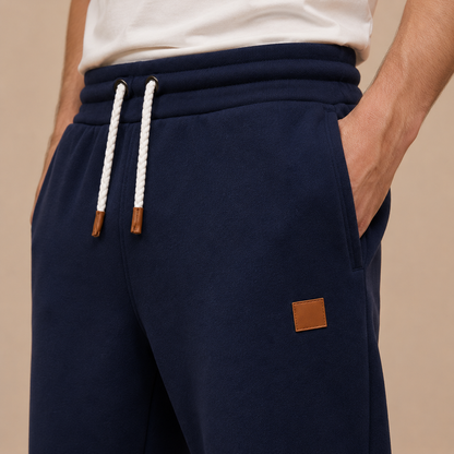 Joggingbroek Heren Casual - Sweatpants met Trekkoord Zijzakken en Elastische Boorden in marineblauw – detailopname op beige studioachtergrond