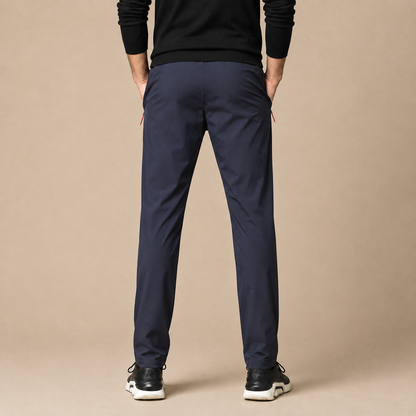Joggingbroek Heren Sportief - Trainingsbroek met Ritszakken en Trekkoord in marineblauw – achteraanzicht op beige studioachtergrond