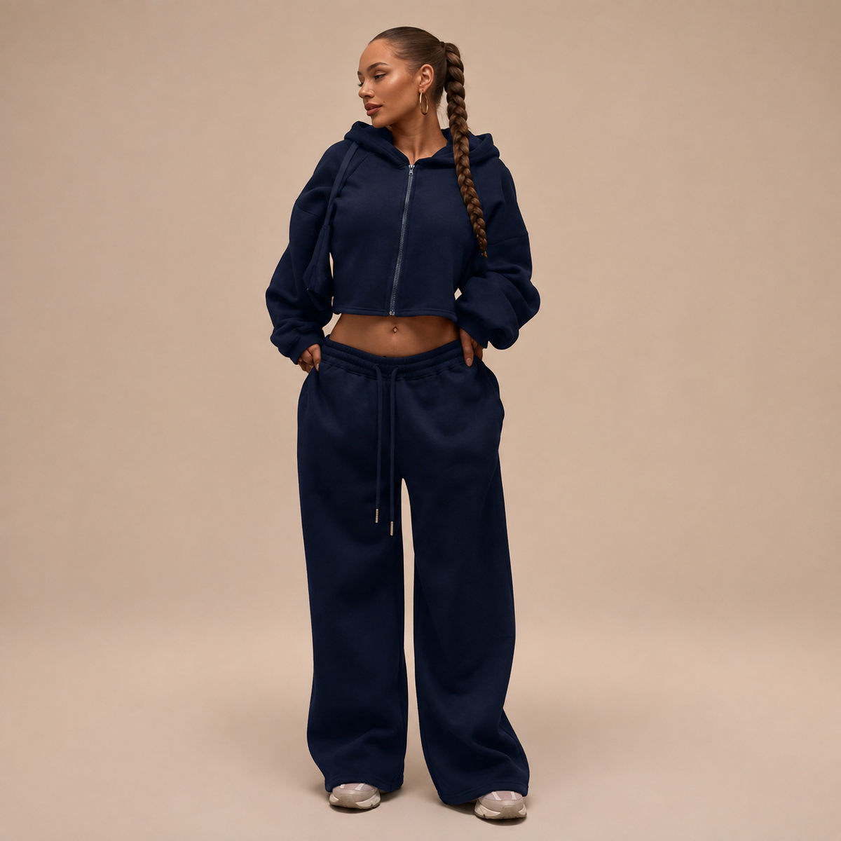 Donkerblauw damesjoggingpak met korte ritshoodie en wijde broek, vooraanzicht.