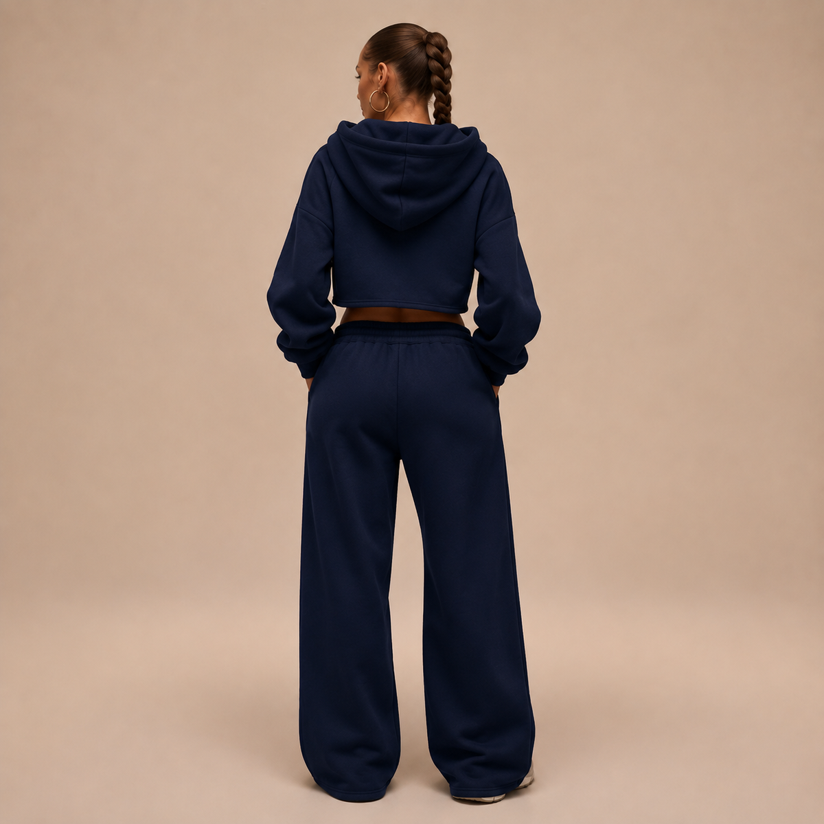 Achteraanzicht van een donkerblauw damesjoggingpak met cropped hoodie en wijde broek.