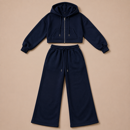 Donkerblauw damesjoggingpak met cropped ritshoodie en wijde broek, plat neergelegd.
