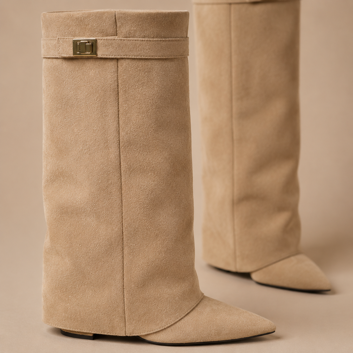 Detail van de suèdelook schacht, sierband en metalen accent op beige kniehoge laarzen.