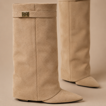 Detail van de suèdelook schacht, sierband en metalen accent op beige kniehoge laarzen.