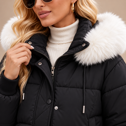 Detail van zwarte gewatteerde damesjas met witte faux-fur capuchon en ritssluiting