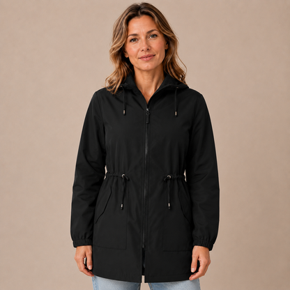 Regenjas dames lang – waterafstotende parka met capuchon en taillekoord in zwart – vooraanzicht op beige studioachtergrond