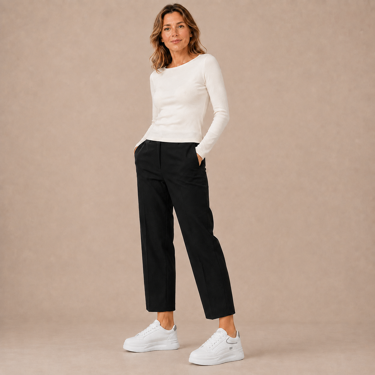 Witte lage platformsneakers bij een witte top en zwarte broek, volledige outfit.