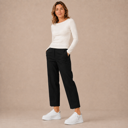 Witte lage platformsneakers bij een witte top en zwarte broek, volledige outfit.