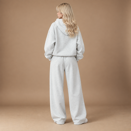 Achteraanzicht trainingspak dames lichtgrijs met hoodie en wide leg broek