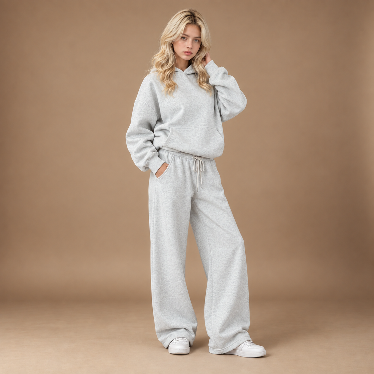 Trainingspak dames lichtgrijs hoodie en wijde broek studio vooraanzicht