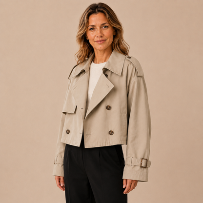 Beige cropped damestrenchcoat met dubbele knopenrij, schuin van voren op een model