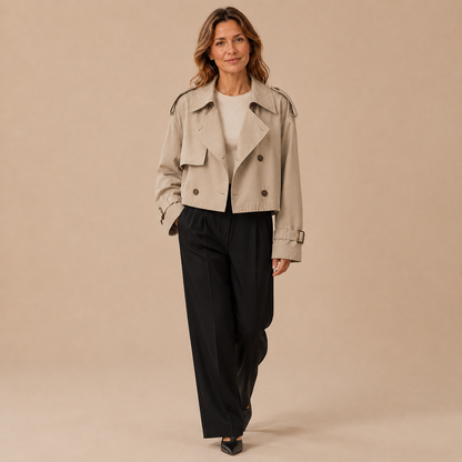 Model draagt een beige cropped trenchcoat met zwarte broek en lichte schoenen