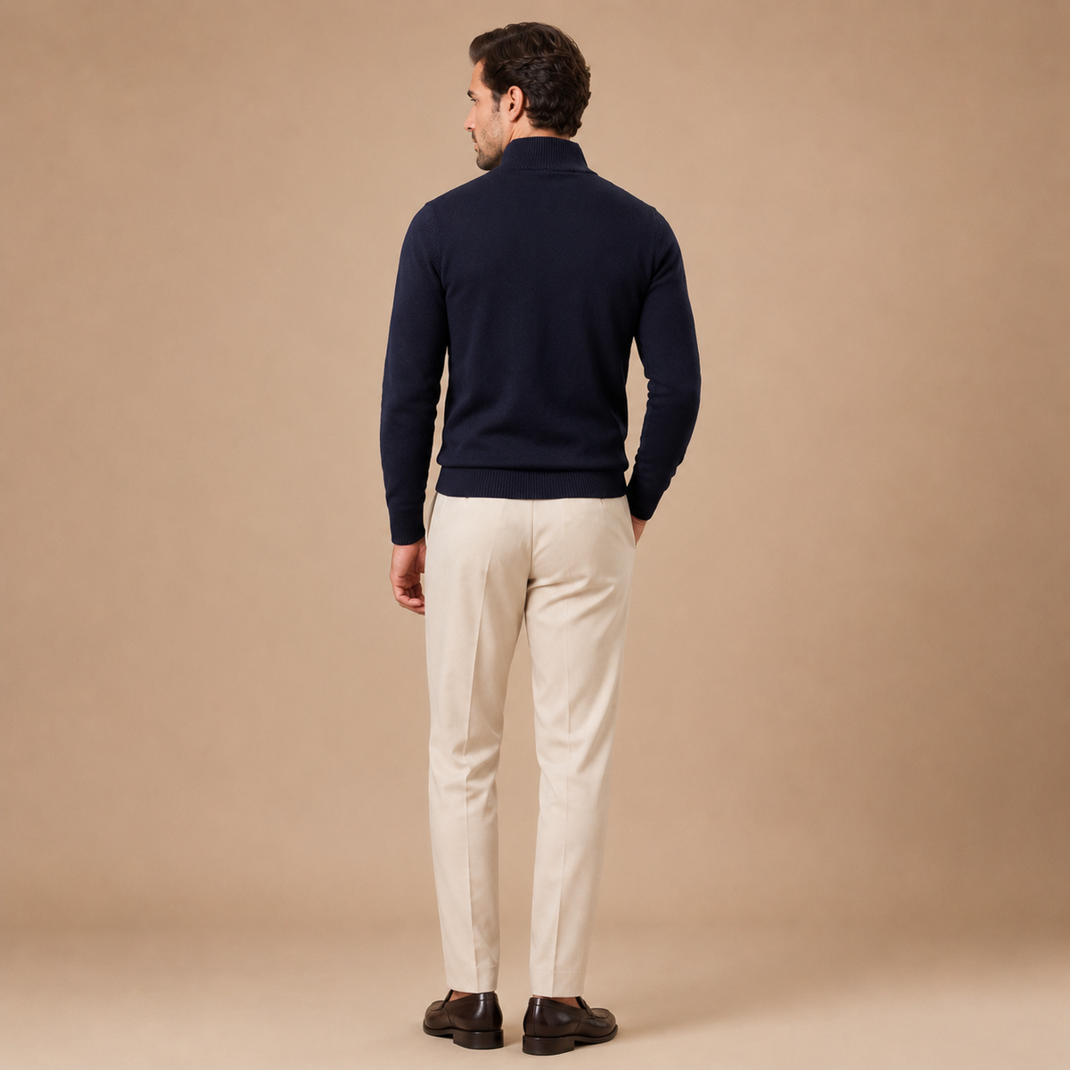 Achteraanzicht van een donkerblauwe herentrui, gecombineerd met een beige pantalon.