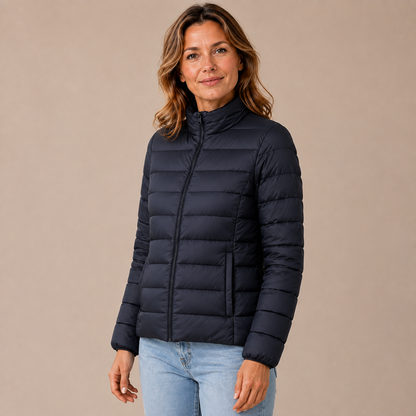 Tussenjas dames gewatteerd – pufferjas met rits en opstaande kraag in zwart – driekwartaanzicht op beige studioachtergrond